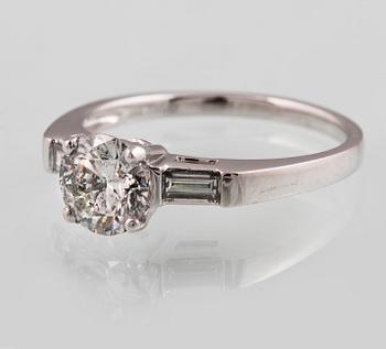 RING, 18K vitguld med briljantslipad diamant ca 1.05 ct samt 2 baguettslipade diamanter ca 0.17 ct. Vikt 3,2 gram.