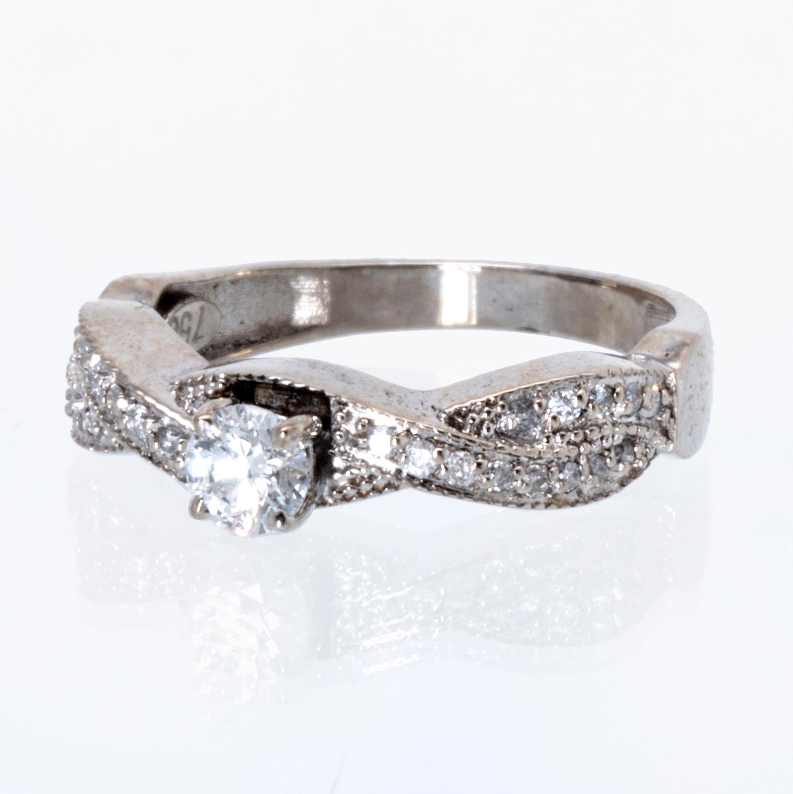 Ring 18K vitguld med 1 briljant ca 0,30 ct och briljanter ca 0,15 ct totalt.