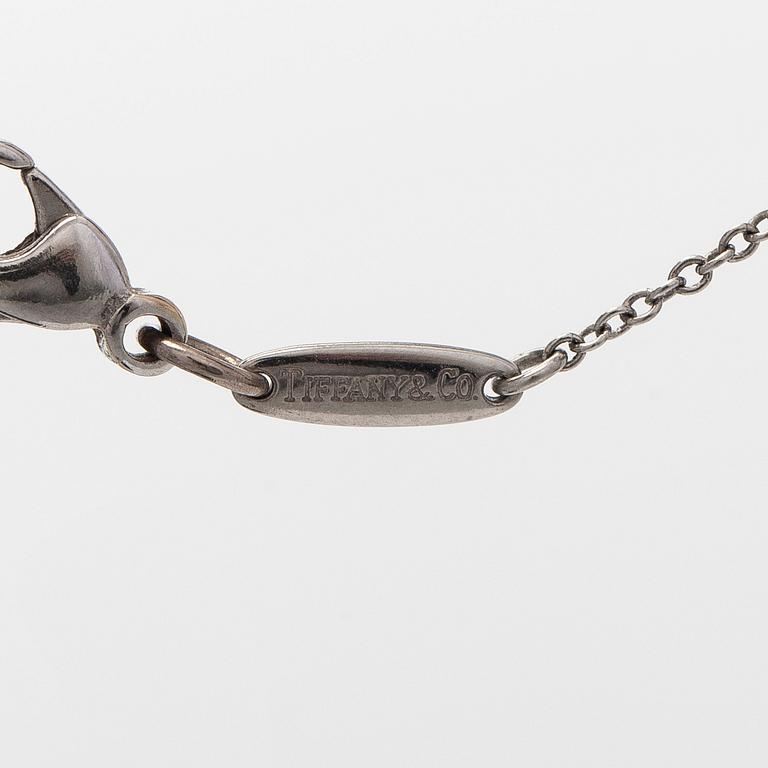 Tiffany & Co, Elsa Peretti, kaulakoru, risti, platinaa ja vuorikristallia.