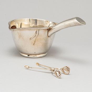 A Mexican sterling silver sauce pan and a Georg Jensen sugartangs, 20th century.