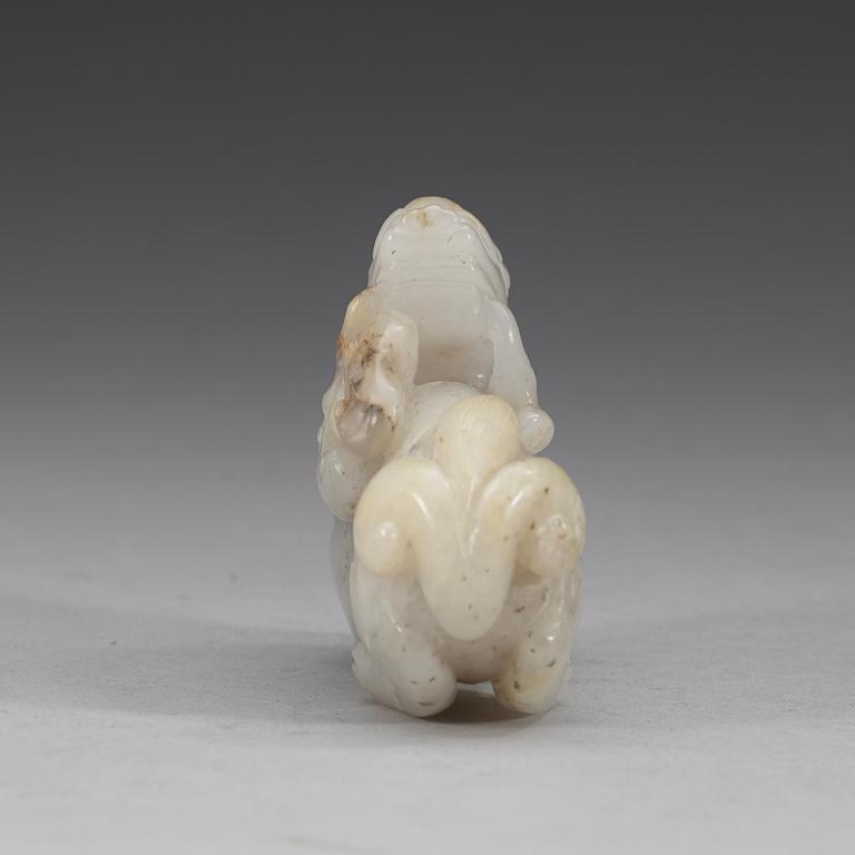 A carved nephrite figure of a reclining dragon carrying lingzhi fungus in his mouth, Qing dynasty (1644-1912).