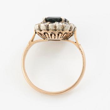 Ring in low carat gold with dark sapphire and white stones.
