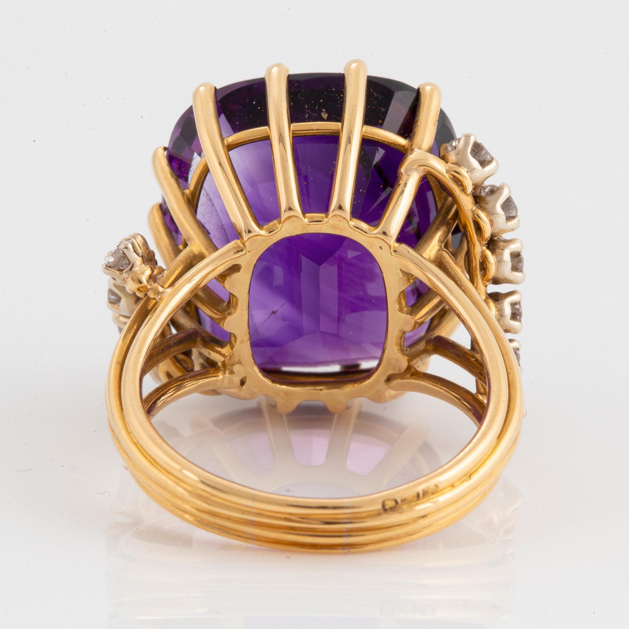 Ring 18K guld med en fasettslipad ametist och runda briljantslipade diamanter.