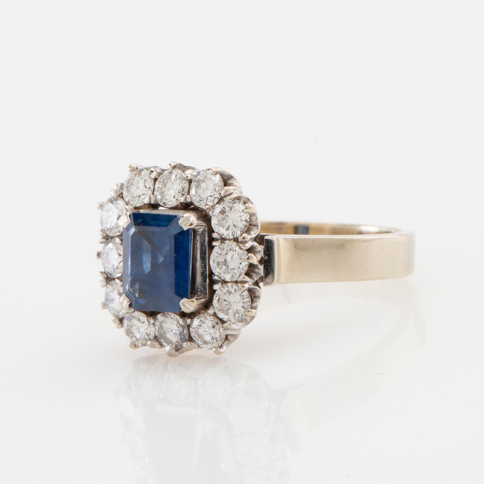 Ring in 18K white gold set with a step-cut sapphire and round brilliant-cut diamonds.