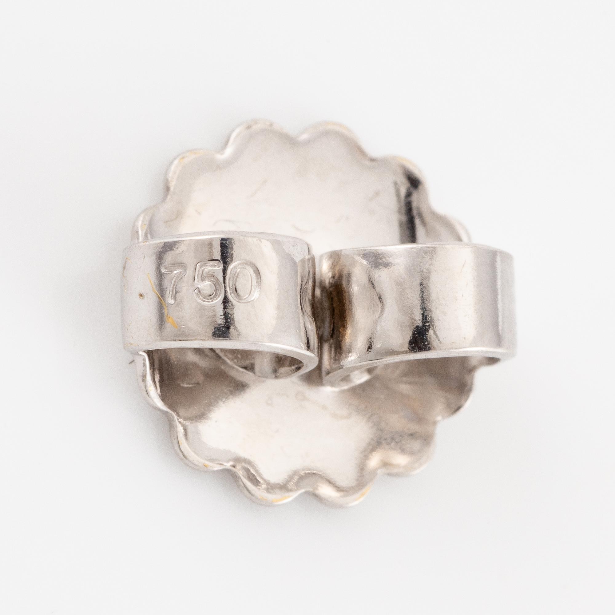 A pair of earrings in 18K white gold set with two round brilliant-cut diamonds.