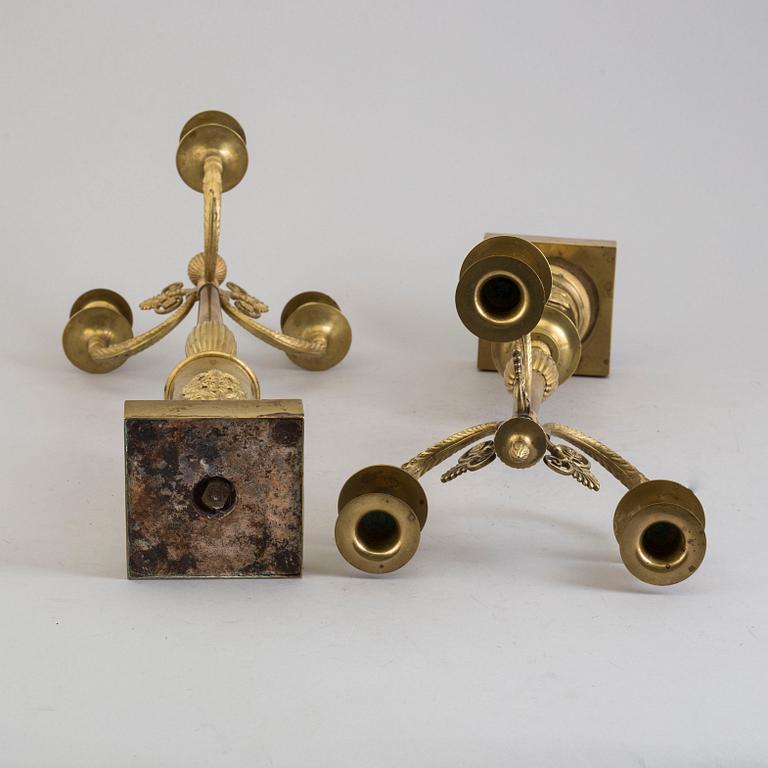 A pair of early 19th century brass candelabra for three candles.