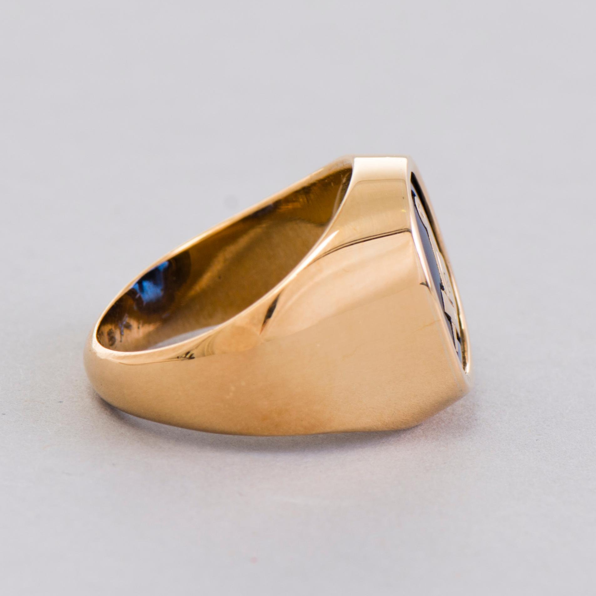A gold 18K Freemason ring with a synthetic blue sapphire.
