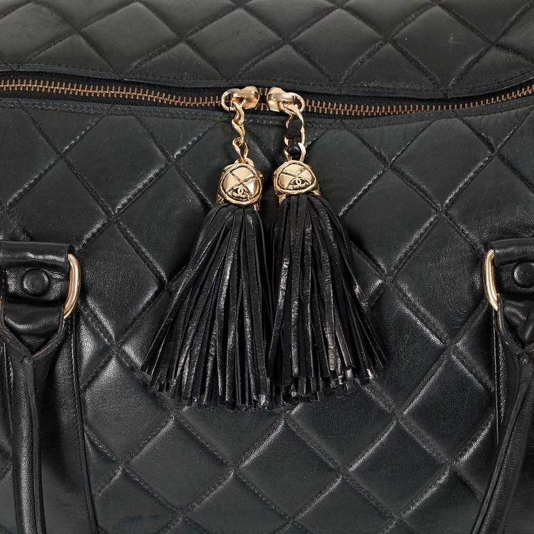 CHANEL, a black leather weekend bag.