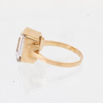 An 18K gold ring set with a step-cut synthetic white spinel.