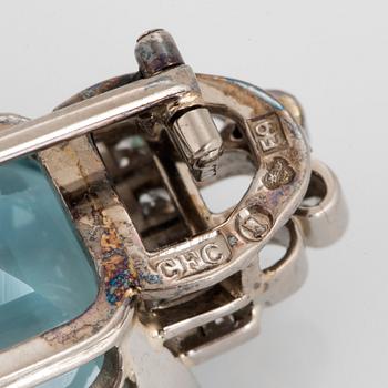A CF Carlman brooch in 18K white gold set with a faceted aquamarine and eight-cut diamonds.