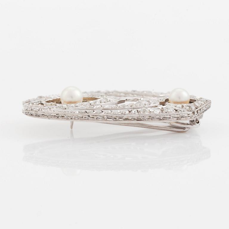 A silver brooch set with old- and rose-cut diamonds and pearls.