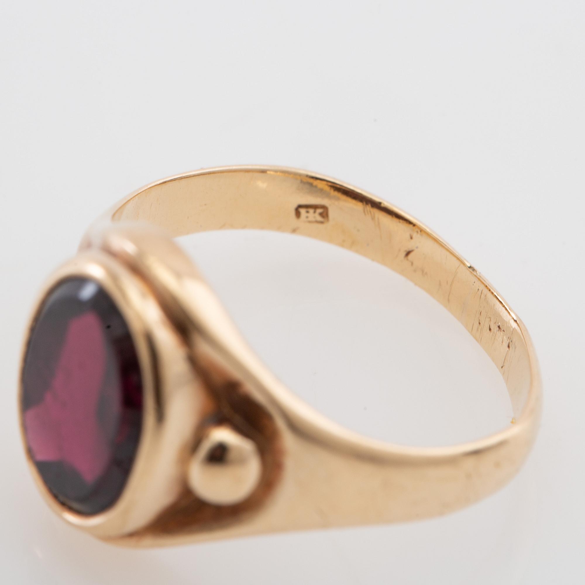 Ring 18K guld med en ovalt slipad granat.