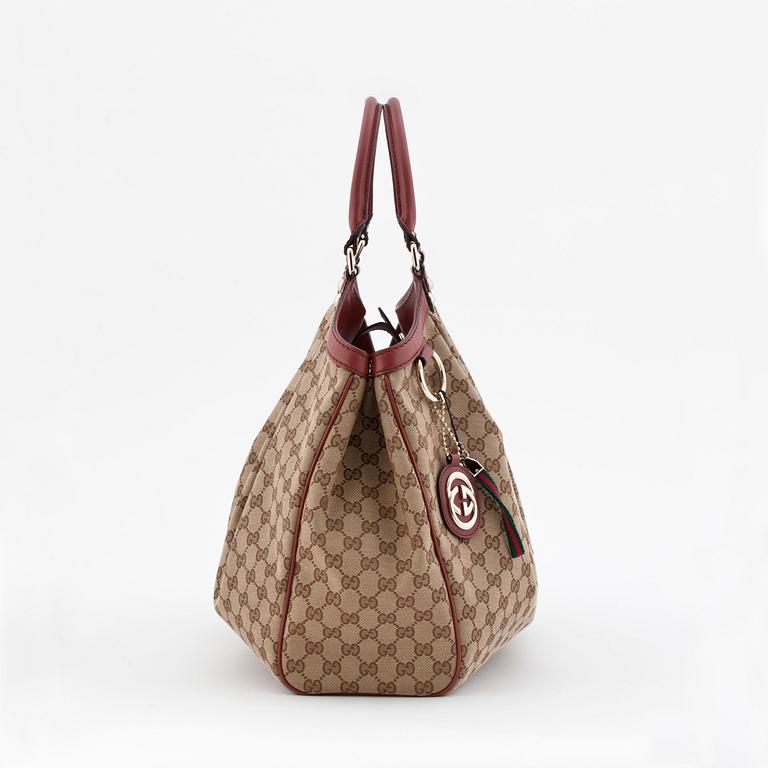 GUCCI, a monogram canvas and red leather tote bag, "Sukey".