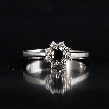 RING, vitguld 14K, briljantslipade diamanter. Mittstenen svartfärgad diamant 0,38 ct, 8 sidostenar tot. 0,18 ct. Intyg.