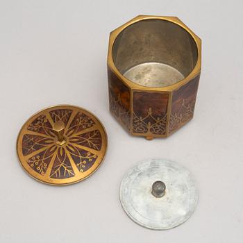 An art nouveau brass and burr walnut tobacco jar and cover from around year 1900.