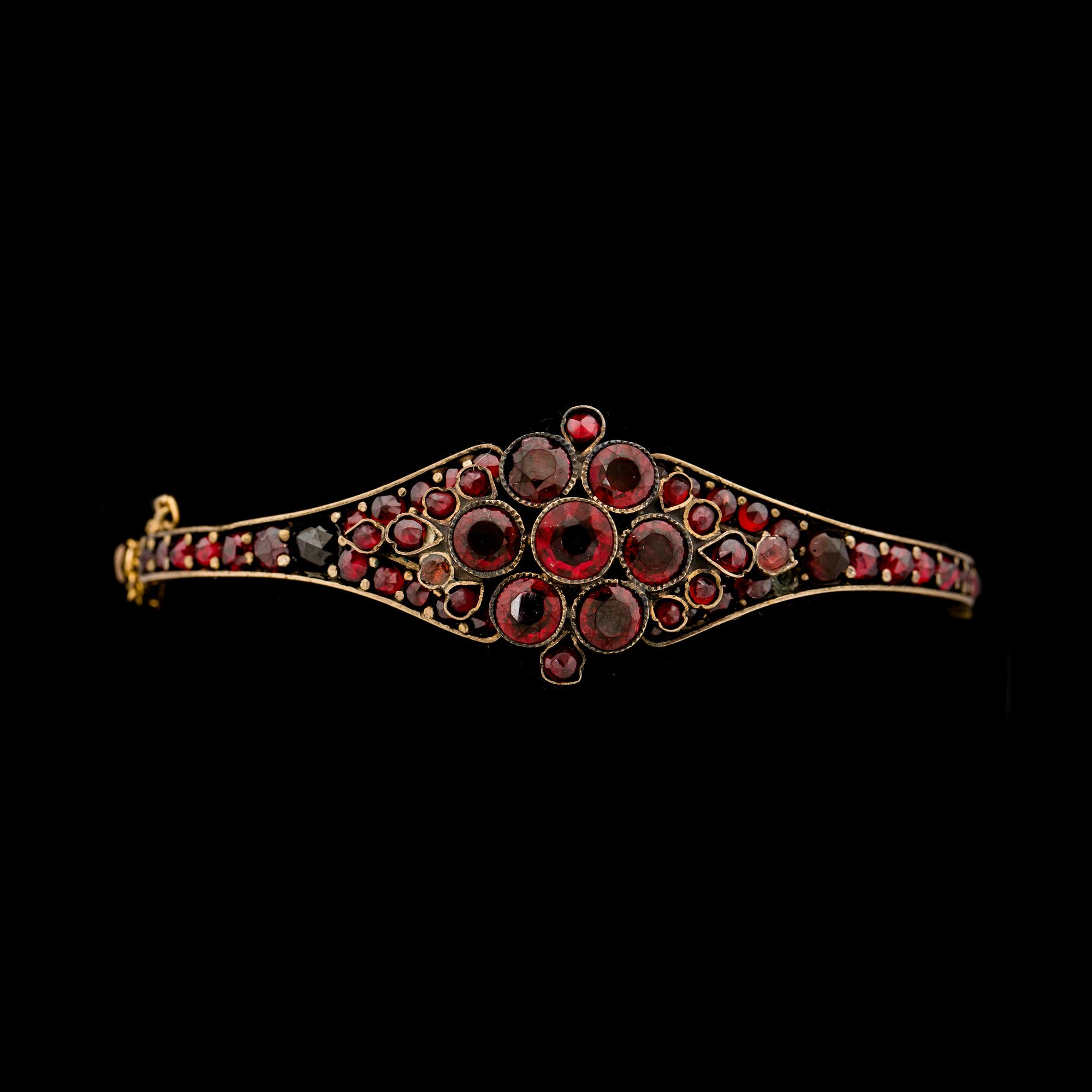 GARNITYR, 4 delar. Gulmetall besatt med granater. Tidigt 1900-tal.