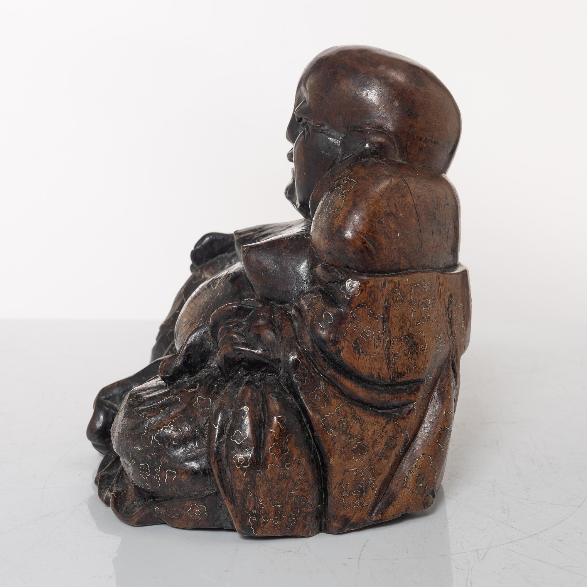A Chinese wooden figure of Budai with silver inlays, Qing dynasty (1644-1912).