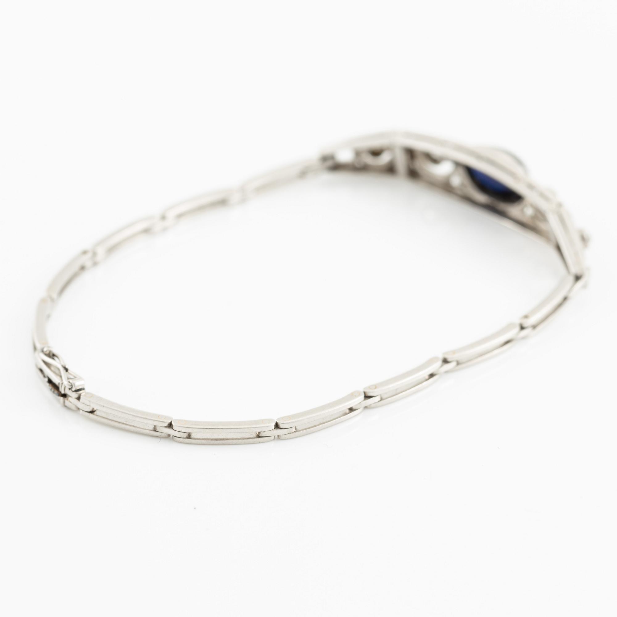A bracelet in platinum set with old-cut diamonds and a blue stone.