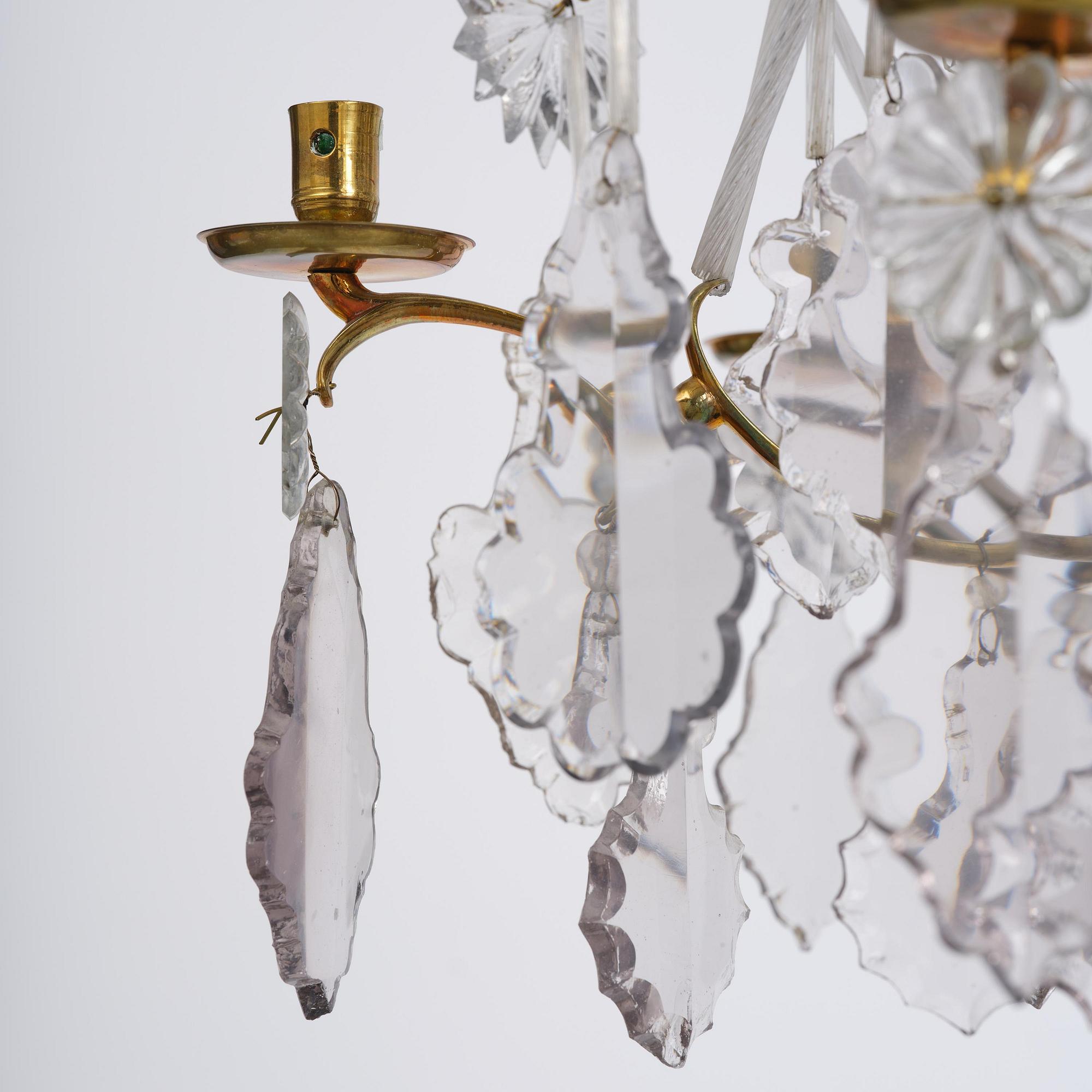 A near pair of rococo-style gilt brass and cut glass six-branch chandeliers, 19th century incorporating older elements.