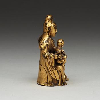 A seated gilt bronze figure of Guanyin with a small boy, Qing dynasty, 18th Century.