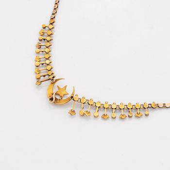 A gold necklace set with pearls.