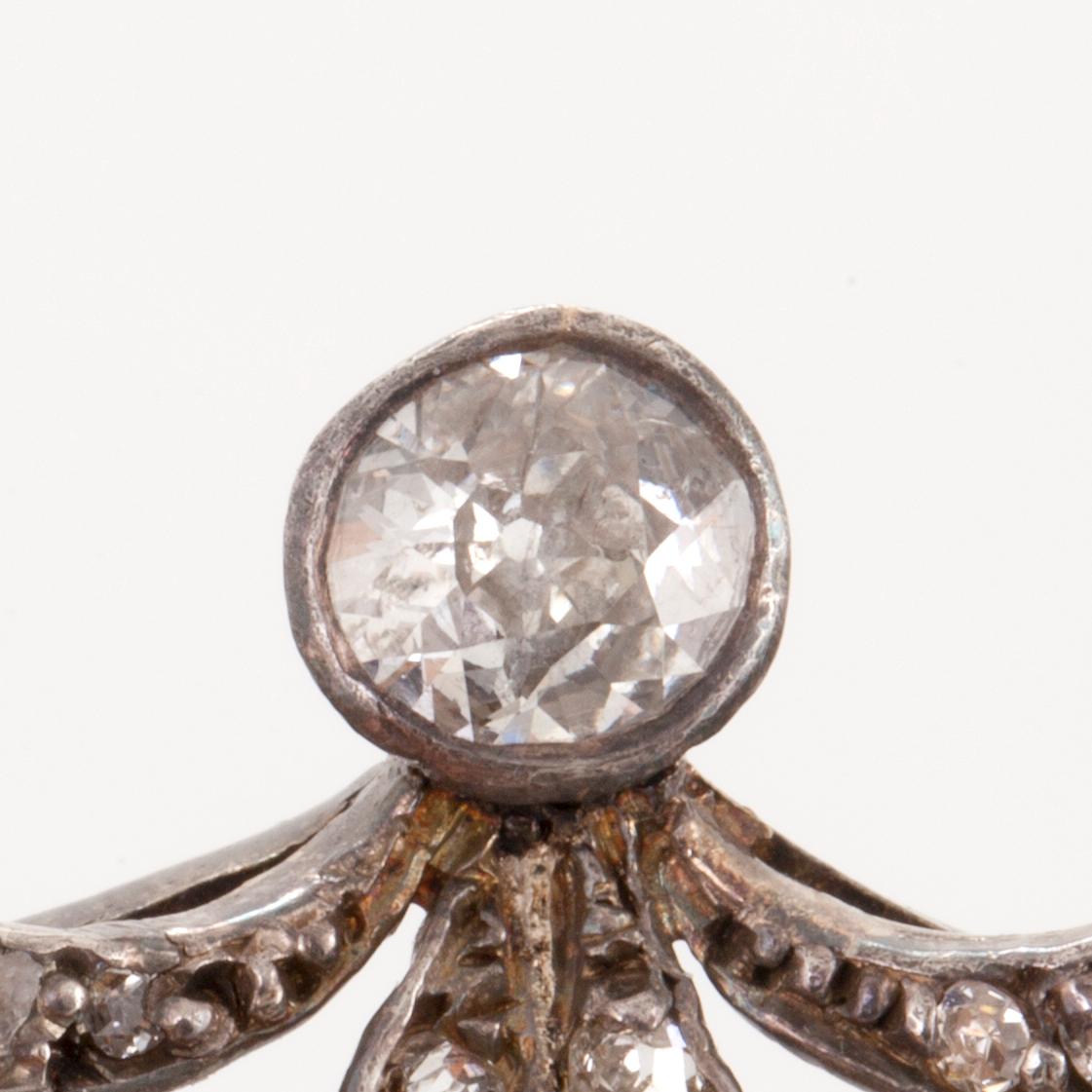 A brooch set with antique- and old-cut diamonds and pearls. The larger diamond approximately 0.50 ct.