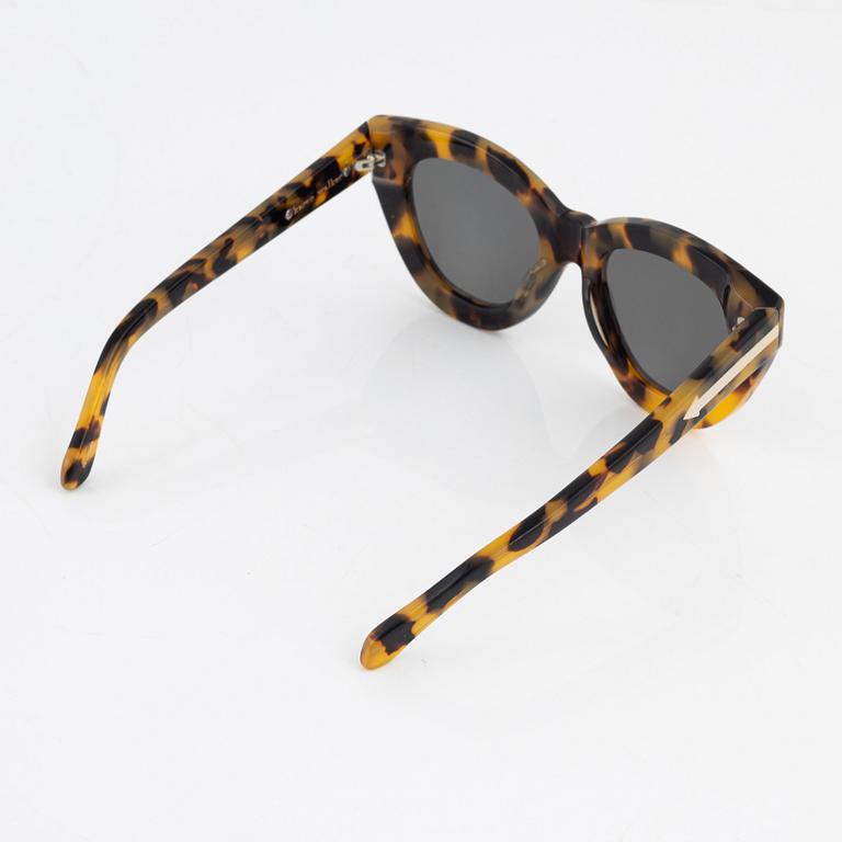 Karen Walker, a pair of tortoise "Anytime" sunglasses.