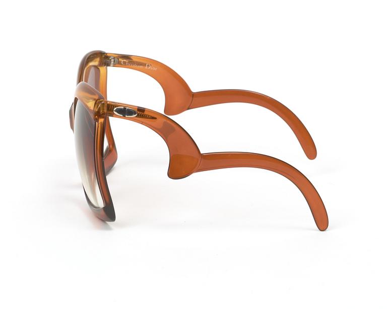 A clutch and sunglasses by Christian Dior.