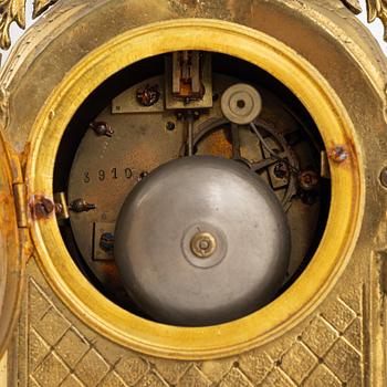 A set of two Louis XVI-style candle sticks and a mantle clock, late 19th century.