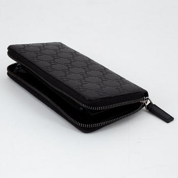 Gucci, an embossed böack leather wallet.