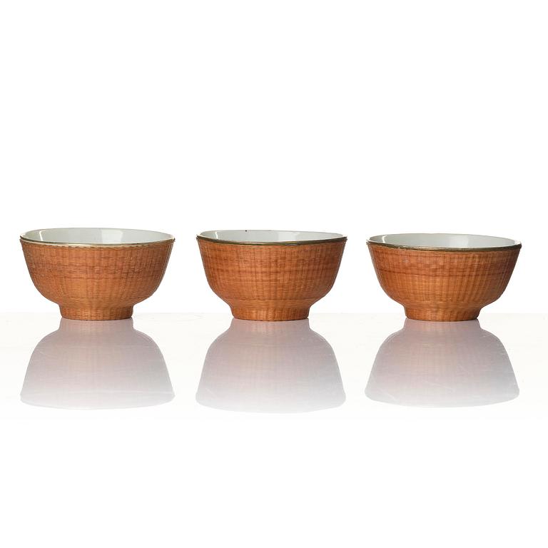 Skålar, 11 stycken porslin och korgflätning, omkring 1900.