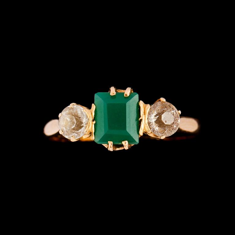 RING, 18K guld med fasettslipade vita stenar samt syntetisk smaragd, kattfotstämplad, 1921. Vikt 2,3 g.