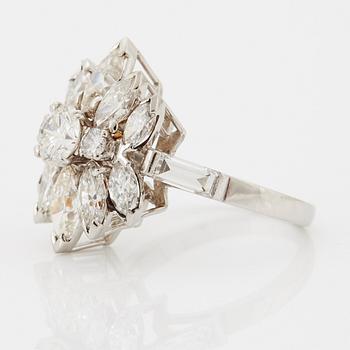 A platinum ring set with round brilliant-, navette- and baguette-cut diamonds.