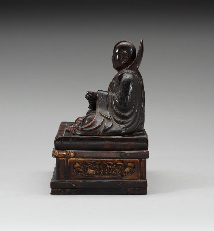 A lacquered wooden Japanese deity on a stand, 19th Century.