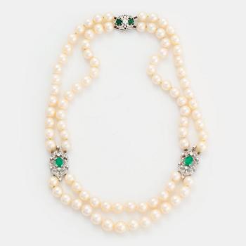 504. A two strand cultured pearl necklace clasp in 18K white gold set with a faceted emerald.