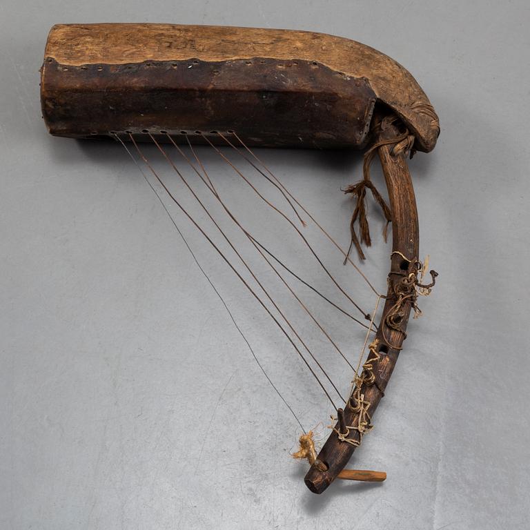 A STRING INSTRUMENT, wood, leather and rope, Africa first half of the 20th century, length 39,5 cm.