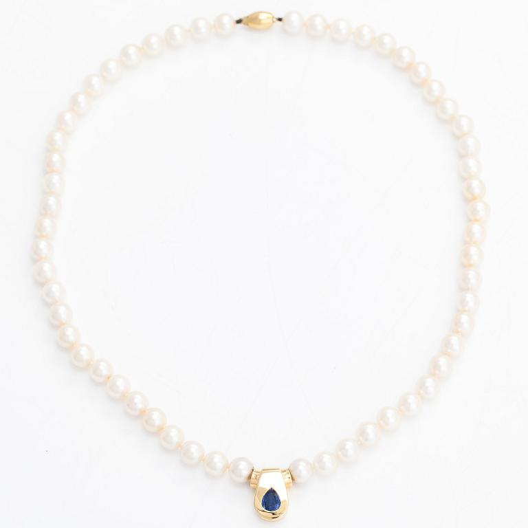 A cultured pearl necklace, pendant in 18K gold with a pearshaped sapphire.