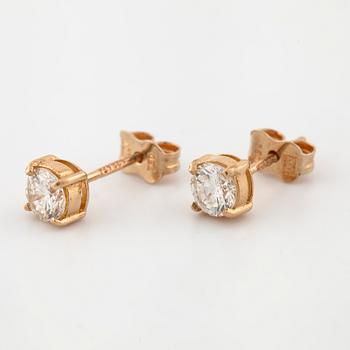 A pair of brilliant cut diamond earrings.