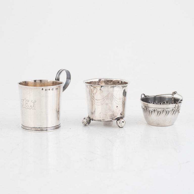 A silver beaker, a cup, a tea strainer and a sugar spoon, including Jacob Richard Bergh, Gävle 1845.