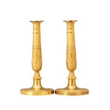 1460. A pair of French Empire early 19th century gilt bronze candlesticks.