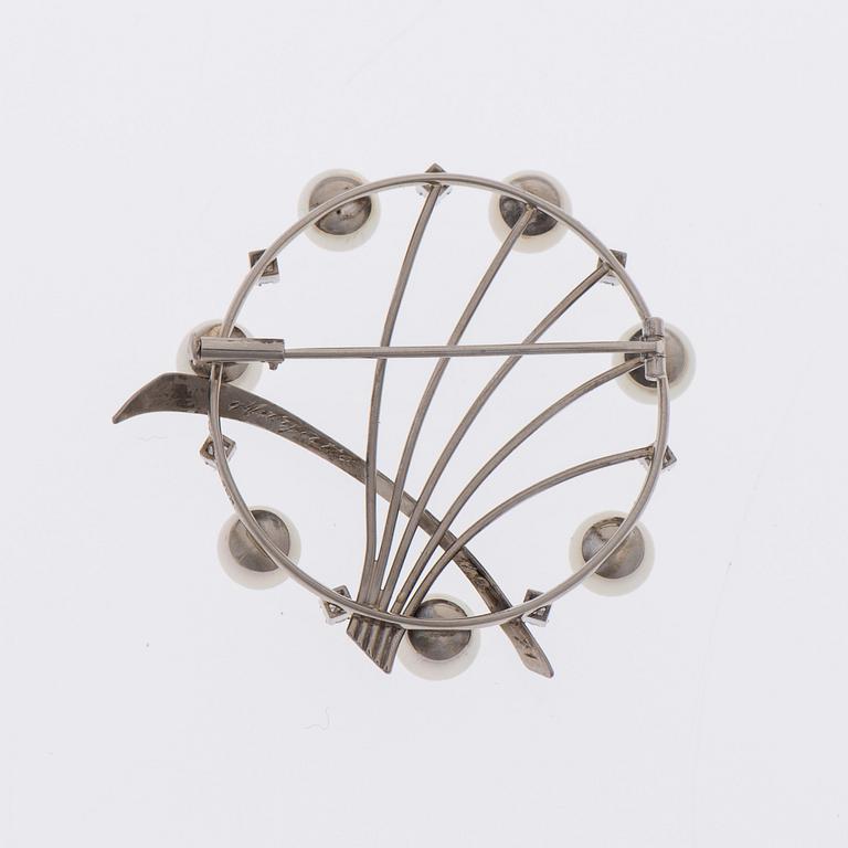 RINTAKORU, 18K valkokultaa, 7 pientä 8/8-hiottua timanttia, viljeltyjä helmiä. Peltonen&Kni Helsinki 1966.