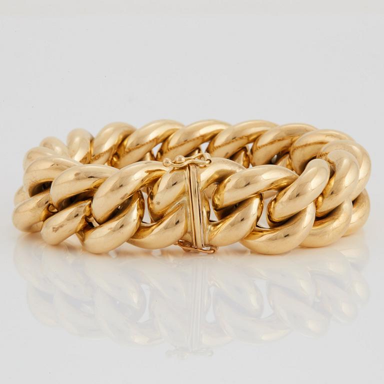 A curb link bracelet in 18K gold.