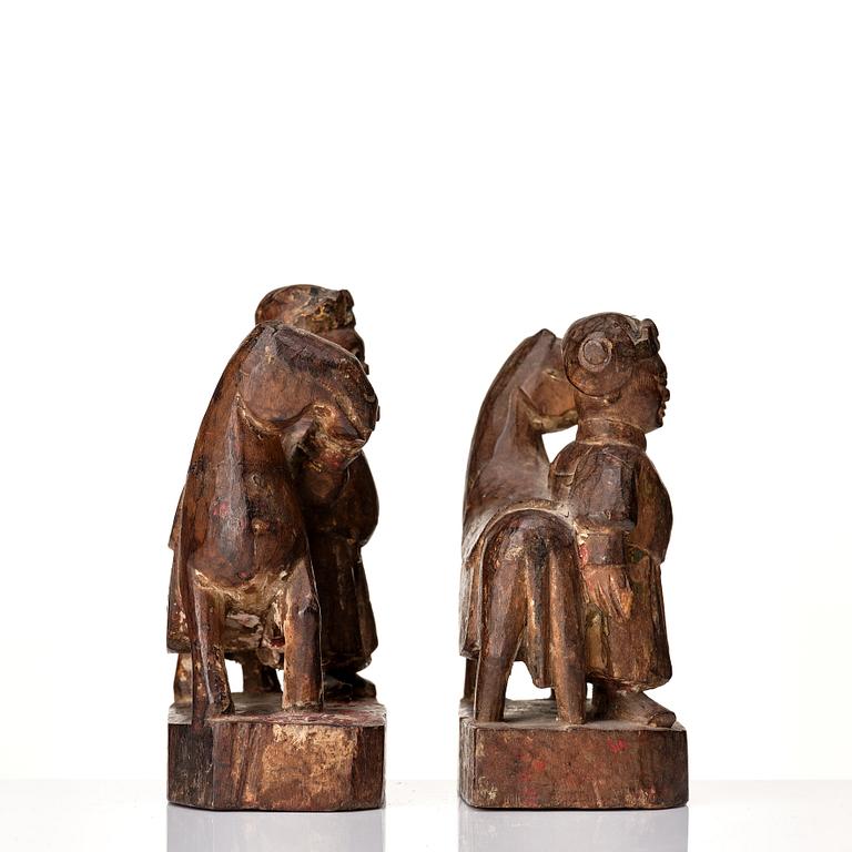 A pair of wooden sculptures of a man with a horse, Qing dynasty, circa 1900.