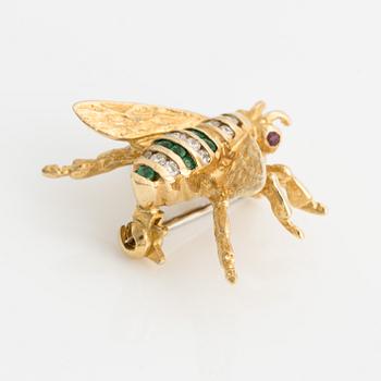 Brooch 18K gold set with round faceted emeralds and rubies, as well as round brilliant-cut diamonds.