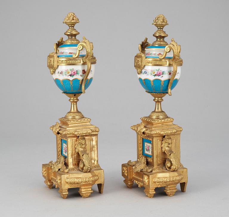A Louis XVI style gilt bronze and porcelaine table clock and a pair of urns with covers.