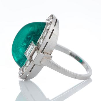 A platinum ring set with a cabochon-cut emerald ca 7 cts and brilliant and baguette-cut diamonds.