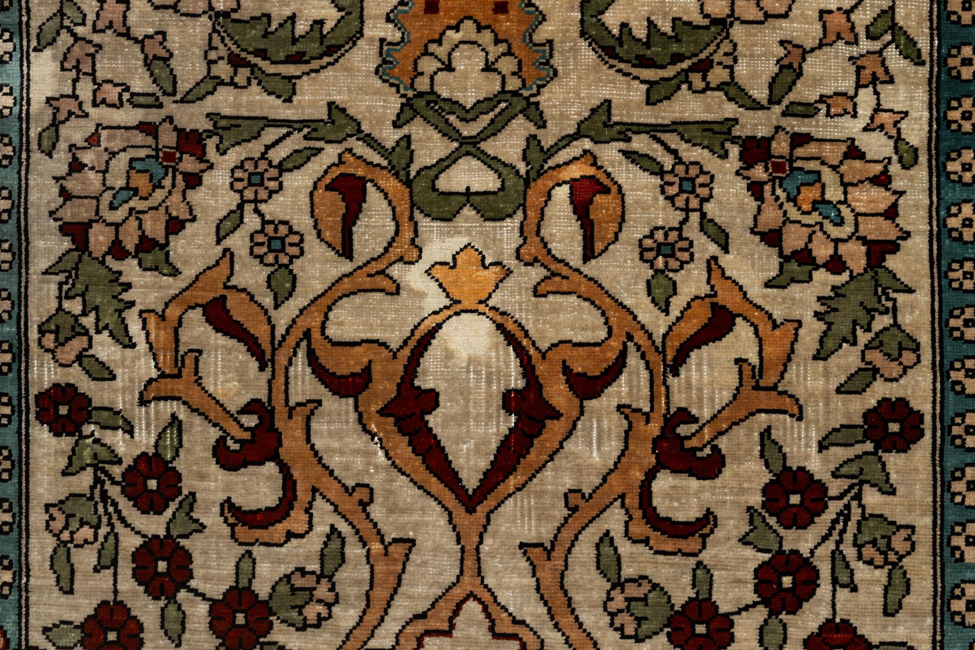 A Hereke silk rug, c. 73 x 52 cm.