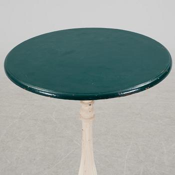 A pair of cast iron chais with wooden seats and a cast iron table, early 20th century.