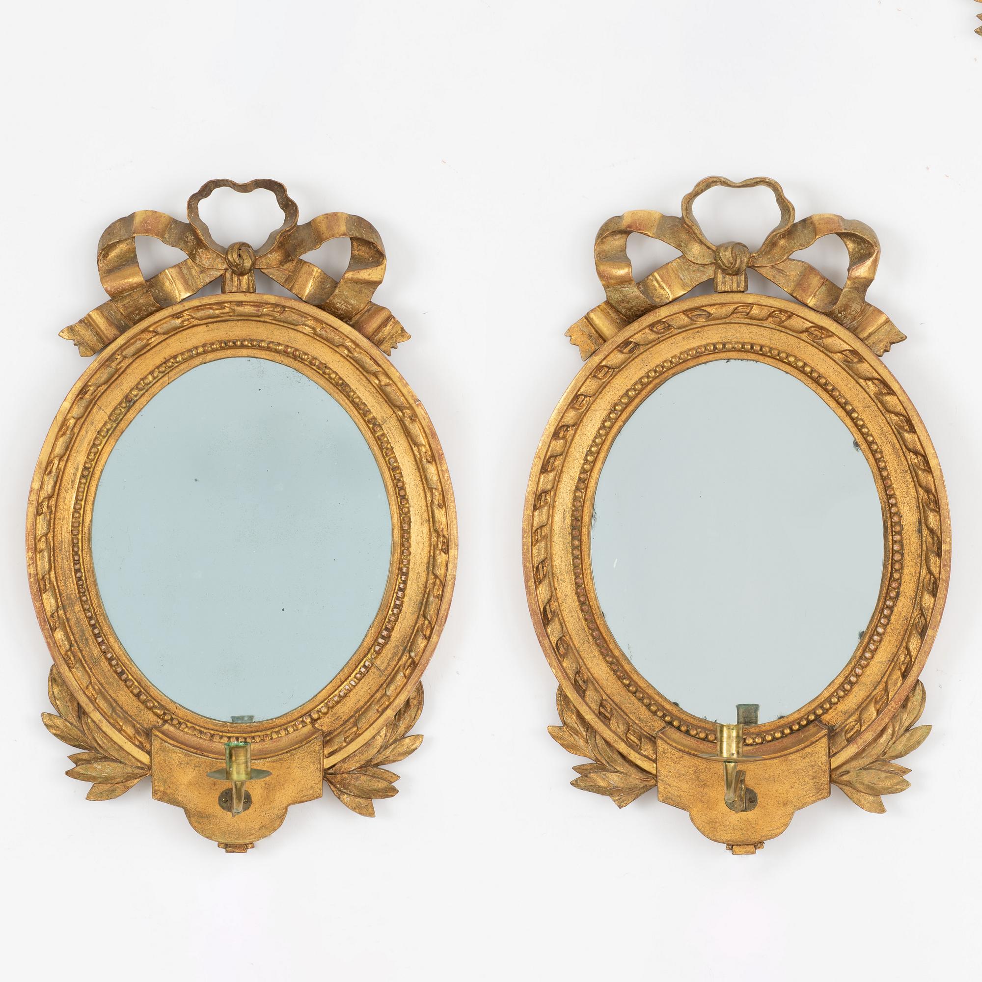 A Gustavian one-branch giltwood girandole mirror (with an associated copy), Stockholm, late 18th century.