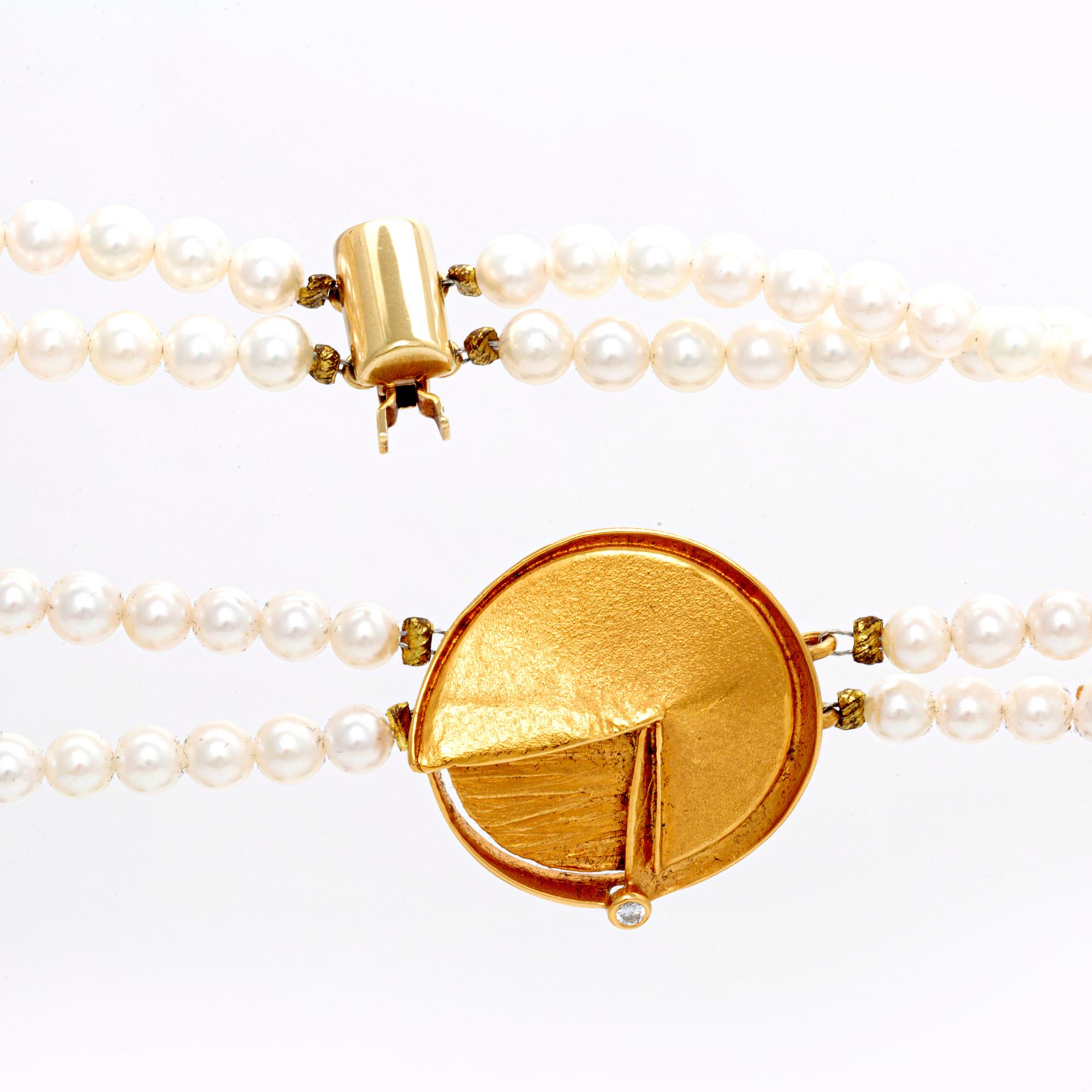 A necklace of cultured pearls and pendant in 18K gold with a brilliant cut diamond.